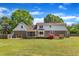 Expansive backyard with brick and vinyl home, a large deck, and mature trees at 3909 Inland Ct, Raleigh, NC 27606