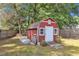 Well-kept red storage shed with white trim and a white door in a fenced yard at 3909 Inland Ct, Raleigh, NC 27606