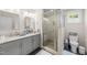 Bright bathroom featuring a glass shower, gray vanity, and modern fixtures at 408 Jerome Rd, Durham, NC 27713