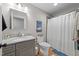 Traditional bathroom with a granite countertop vanity, toilet, and shower with striped curtain at 408 Jerome Rd, Durham, NC 27713