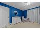 Bedroom with blue walls, white furniture, and a cozy gray armchair at 408 Jerome Rd, Durham, NC 27713