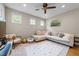 Cozy bonus room with a large sectional sofa, overhead lighting, and ample natural light from multiple windows at 408 Jerome Rd, Durham, NC 27713
