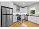 Well-lit kitchen with white cabinets, stainless steel appliances and hardwood floors at 408 Jerome Rd, Durham, NC 27713
