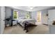 Serene main bedroom with blue walls, a cozy bed, and abundant natural light from large windows at 408 Jerome Rd, Durham, NC 27713