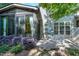Backyard patio with sunroom addition attached to house, featuring lush landscaping and a cozy patio area at 419 Travertine Dr, Cary, NC 27519