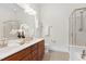 Bright bathroom features dual sinks, wood cabinets, and separate shower and bathtub with glass enclosures at 419 Travertine Dr, Cary, NC 27519