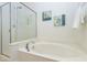 Soaking tub with glass enclosed shower features coastal decor for a relaxing retreat at 419 Travertine Dr, Cary, NC 27519