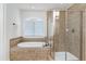 Bright bathroom showcasing tub with tile surround and separate glass shower at 419 Travertine Dr, Cary, NC 27519