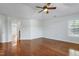 Bright bedroom with gleaming hardwood floors, a ceiling fan, and a large window at 419 Travertine Dr, Cary, NC 27519