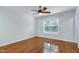 A bedroom featuring wood floors, ceiling fan, and a window with wooded view at 419 Travertine Dr, Cary, NC 27519
