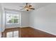 Cozy bedroom with gleaming hardwood floors, a ceiling fan, and large windows providing plenty of light at 419 Travertine Dr, Cary, NC 27519