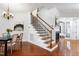 Elegant foyer featuring a staircase with iron spindles, hardwood floors, and a decorative chandelier at 419 Travertine Dr, Cary, NC 27519