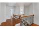 Upstairs hallway featuring wood floors, a staircase with wooden banister and iron spindles at 419 Travertine Dr, Cary, NC 27519