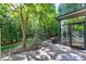 View of patio and backyard surrounded by trees. Also shows part of the sunroom at 419 Travertine Dr, Cary, NC 27519