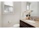Elegant powder room with a granite countertop, dark wood cabinets, and a decorative mirror at 419 Travertine Dr, Cary, NC 27519