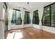 This is a light-filled sunroom featuring large windows offering serene views and wood-look tile floors at 419 Travertine Dr, Cary, NC 27519