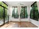 A bright sunroom boasts floor-to-ceiling windows with views of lush greenery and stylish tile flooring at 419 Travertine Dr, Cary, NC 27519