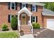 Inviting front entrance with brick steps and a charming covered porch at 4704 Lancashire Dr, Raleigh, NC 27613