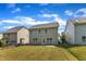 A grassy backyard with a grey home featuring a concrete patio and a blue sky at 4727 Smarty Jones Dr, Knightdale, NC 27545