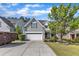 Charming two-story home featuring a two-car garage, manicured lawn, and mature landscaping at 4727 Smarty Jones Dr, Knightdale, NC 27545