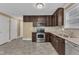 Well-lit kitchen features stainless steel appliances, dark wood cabinets, and tiled backsplash at 4727 Smarty Jones Dr, Knightdale, NC 27545