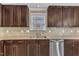 Close-up of kitchen featuring stainless steel appliances, dark wood cabinets, and tiled backsplash at 4727 Smarty Jones Dr, Knightdale, NC 27545