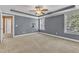Spacious main bedroom with large windows, tray ceilings, and ceiling fan with en-suite bathroom access at 4727 Smarty Jones Dr, Knightdale, NC 27545