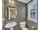 Stylish powder room with a pedestal sink, toilet, and window for natural light at 4727 Smarty Jones Dr, Knightdale, NC 27545