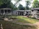 Expansive backyard with a covered patio, white pergola, and colorful flowerbeds creating a serene outdoor space at 5002 Wickham Rd, Raleigh, NC 27606