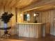 Basement bar area featuring wood-paneled walls, a bar with a marble countertop, and decorative lighting at 5002 Wickham Rd, Raleigh, NC 27606