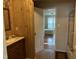 Bathroom featuring wood walls, a granite vanity, and open access to a bedroom at 5002 Wickham Rd, Raleigh, NC 27606