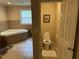 Bright bathroom features a large soaking tub, tiled floor, and separate toilet room at 5002 Wickham Rd, Raleigh, NC 27606