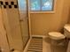 Bathroom features tiled shower, a window, and white commode at 5002 Wickham Rd, Raleigh, NC 27606