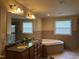 Bathroom with a double vanity, a large soaking tub, and a separate glass-enclosed shower at 5002 Wickham Rd, Raleigh, NC 27606