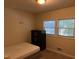 Cozy bedroom features neutral walls, carpet, a window, and dark wood dresser at 5002 Wickham Rd, Raleigh, NC 27606