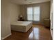 Bare bedroom features hardwood floors, a bright window, and neutral walls at 5002 Wickham Rd, Raleigh, NC 27606