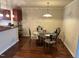 Cozy dining area featuring dark wood floors, a glass-top table, and seating for four at 5002 Wickham Rd, Raleigh, NC 27606