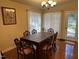 Formal dining room with a dark wood table, seating for six, and bright natural light at 5002 Wickham Rd, Raleigh, NC 27606