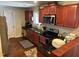 Features a well-equipped kitchen with granite countertops, dark wood cabinets and stainless steel appliances at 5002 Wickham Rd, Raleigh, NC 27606