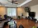 Living room featuring hardwood floors, a ceiling fan, and an entertainment center at 5002 Wickham Rd, Raleigh, NC 27606