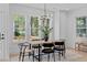 Dining area with large windows, a modern light fixture, and a wooden table with stylish seating at 5049 Lundy Dr # 102, Raleigh, NC 27606