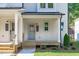 Charming front porch with a gray door, painted white siding, and manicured landscaping at 5049 Lundy Dr # 102, Raleigh, NC 27606