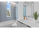 Bright bathroom features blue tile accent wall, modern fixtures, and soaking tub with window at 511 S Bloodworth St # 102, Raleigh, NC 27601