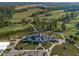 Aerial view displays the club house, golf course, landscaping, parking, and surrounding scenery at 525 Morning Oaks Dr, Holly Springs, NC 27540