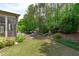 Expansive backyard featuring mature trees, lush lawn, patio seating, and screened porch at 525 Morning Oaks Dr, Holly Springs, NC 27540