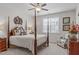 Bedroom features 4 poster bed, a ceiling fan, and a bright window at 525 Morning Oaks Dr, Holly Springs, NC 27540