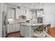 Modern kitchen with white cabinets, stainless steel appliances, granite countertops and large center island with seating at 525 Morning Oaks Dr, Holly Springs, NC 27540