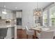 Well-appointed kitchen with white cabinets, stainless steel appliances, a breakfast nook, and modern lighting fixtures at 525 Morning Oaks Dr, Holly Springs, NC 27540
