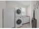 Well-lit laundry room with sink, cabinetry, and stacked washer and dryer at 525 Morning Oaks Dr, Holly Springs, NC 27540