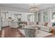 Open concept living space with a kitchen, white sofa, and large windows providing ample natural light at 525 Morning Oaks Dr, Holly Springs, NC 27540